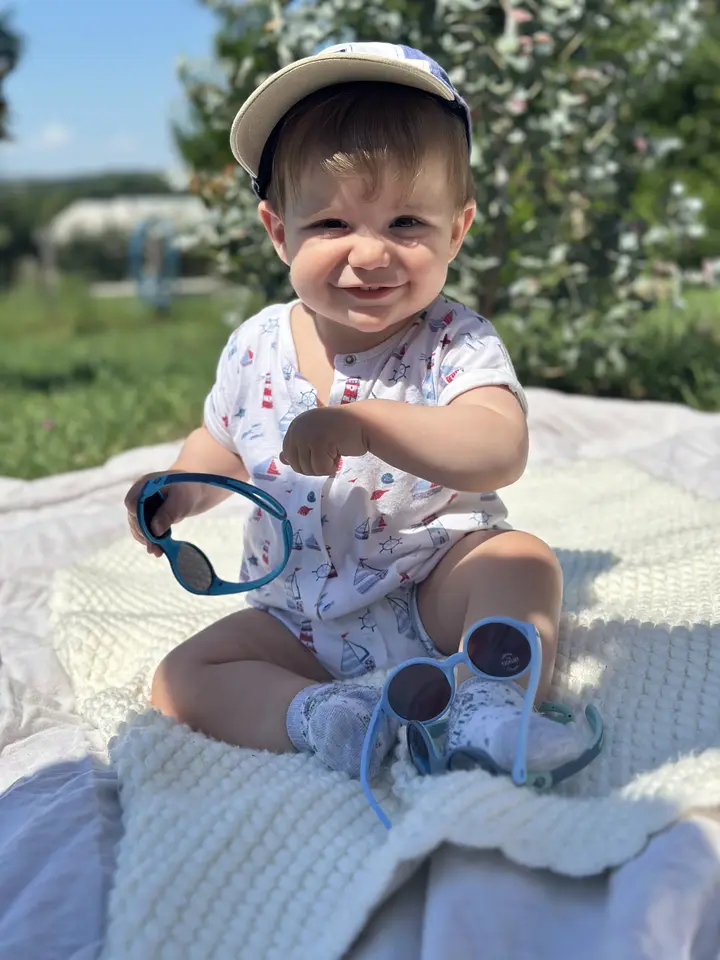 enfant souriant avec des lunettes de soleil